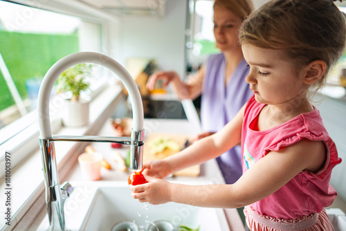 Wallpaper Mural Little chef washing vegetables in a sunny kitchen Torontodigital.ca