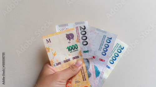 Quadro su tela Woman hand showing various argentine peso banknotes, representing inflation, eco