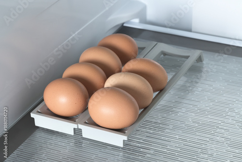 Macro photography of brown chicken eggs on the glass shelf in the refrigerator