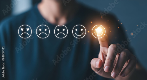 Person selects the happy smiley face from a range of emotions indicating a positive customer review online