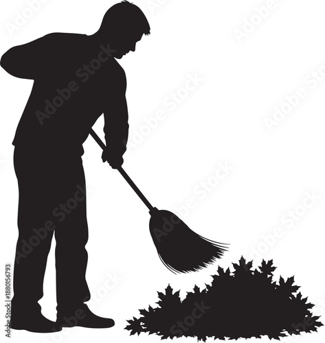 Silhouette of a man sweeping a pile of fallen autumn leaves with a broom, seasonal yard cleanup