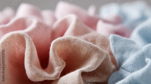 Close-up of a pile of fabric scraps. the fabric scraps are in various shades of pink, light blue, and light pink.