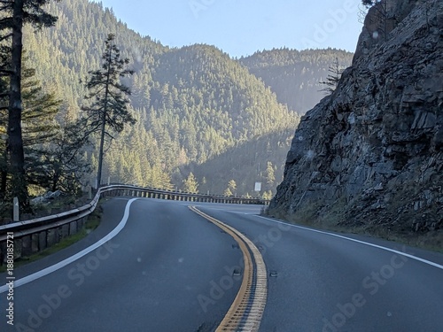 Tableau sur toile A deserted country road curves through a forested valley near Crescent City, California, with cliffs and guardrails capturing solitude, travel, and calm on a clear day