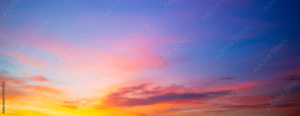 Obraz premium Beautiful sunset and sunrise skies, with purple and orange clouds in various colors,Panoramic view of a breathtaking sunset sky featuring a dramatic blend of purple, pink, and golden orange clouds.