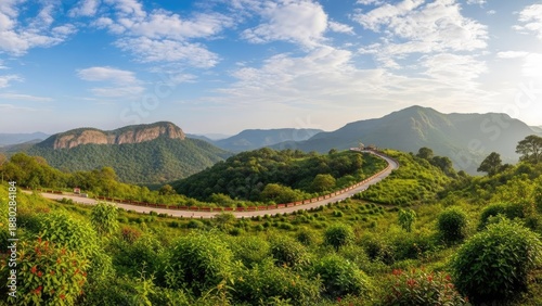 Winding road through lush green mountains with blue sky