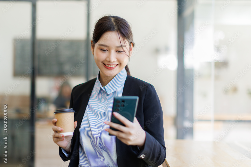 Obraz premium Smiling business woman using modern smartphone standing in office, making call, download new business application, chatting, texting 