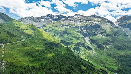 Explore the scenic Grossglockner High Alpine Road, a stunning mountain pass with breathtaking views of green slopes and rocky peaks. An ideal destination for adventure and tourism.