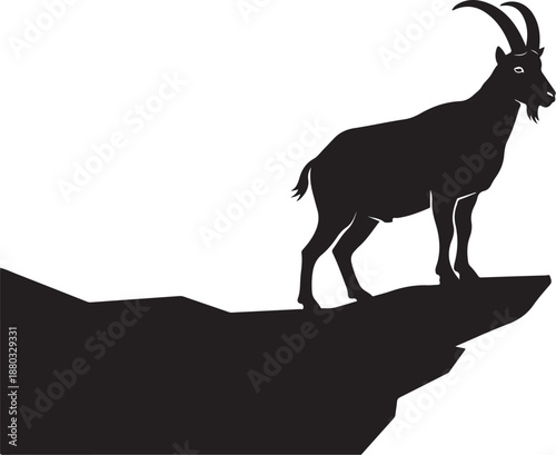 Goat standing on edge of cliff in black silhouette