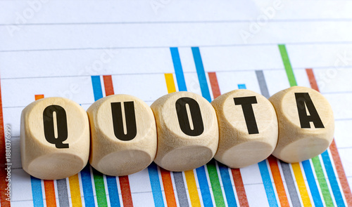 Quota concept on round wooden blocks over colorful bar chart background
