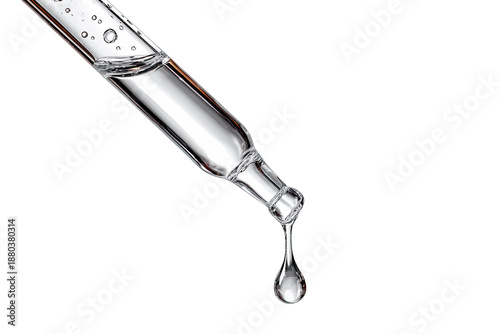 Close-up of a clear liquid dripping from a glass dropper, isolated on black