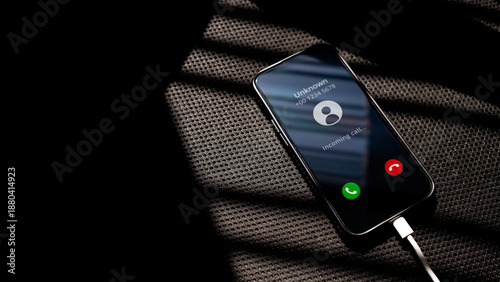 Foto Unknown Incoming call on smartphone charging on a black chair textured surface