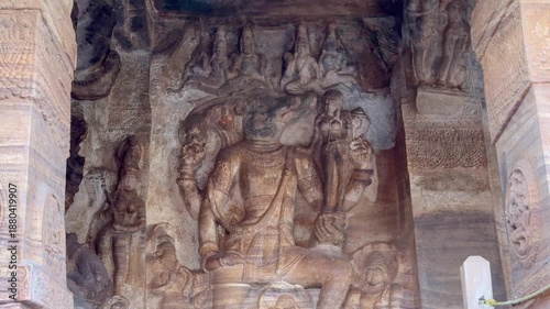 Varaha avatar of Lord Vishnu rescuing Bhudevi, gently carrying her on a lotus as she places her hand on his face in faith. Sheshnaag carved below. 1300-year-old Badami Caves, Karnataka.