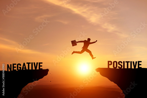 Bilde på lerret Silhouette of a businessman jumping over gap to change mindset from negative to positive