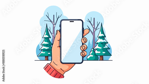 Hand holding smartphone in snowy forest with evergreen trees