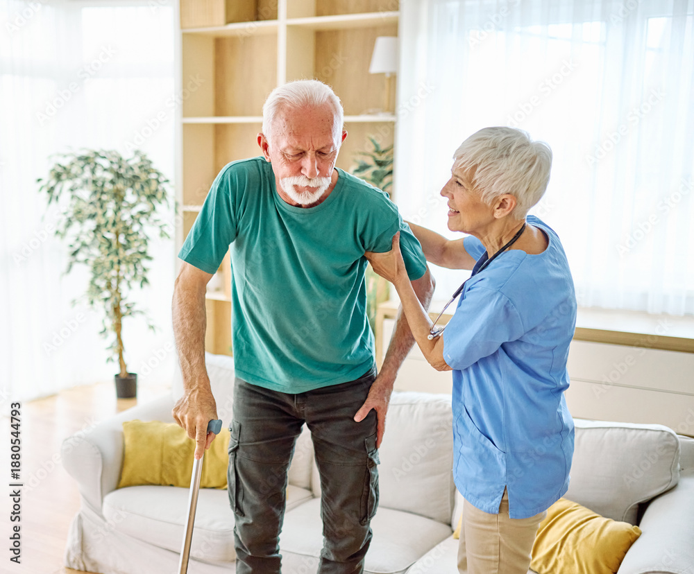 Obraz premium Doctor or nurse caregiver helping senior man holding walking cane at home or nursing home