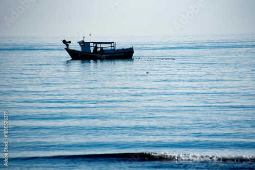A small fishing boat fishing near the beach