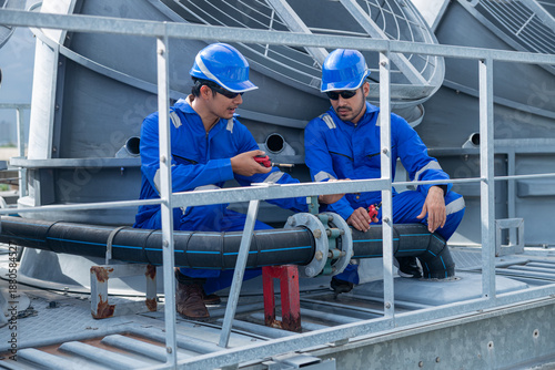 Engineers performing maintenance on rooftop ventilation system