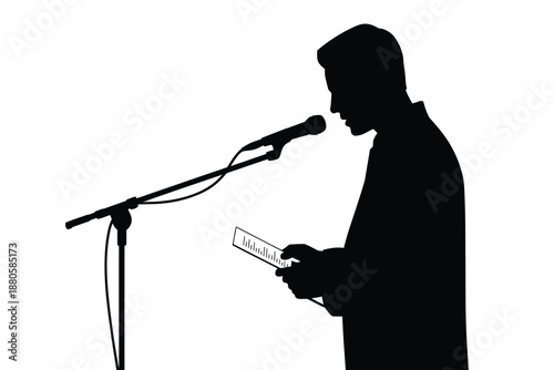 A man in silhouette speaks into a microphone while reading notes