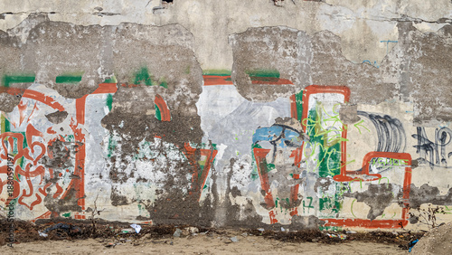 Foto Muro urbano scrostato con graffiti consumati, tracce di memoria e degrado cittad