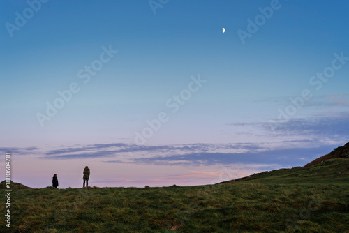 Canvastavla Wicklow Head dusk with two silhouetted  figures, textured grass and half-moon ov