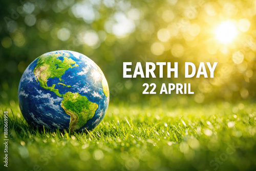 Earth Day Globe resting on grass with sun shining for environmental awareness campaign