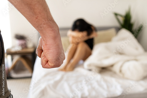 Cuadro en lienzo Portrait of a frightened to death Asian woman sitting on bed and hiding her face behind hands