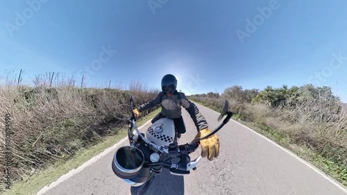 Chico con casco oscuro en motocicleta clásica rodando por carretera y bosque en día soleado ,toma grabada en 4k