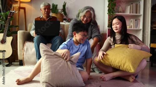 teasing. sisters and brothers are having fun teasing each other. Asian sibling having fun playing game. Happy Family leisure activity with parents and children playing video game living room at home