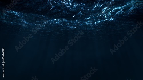 View of the ocean waves from under the water. Seamlessly looped video. Dramatic blue lighting and light rays.