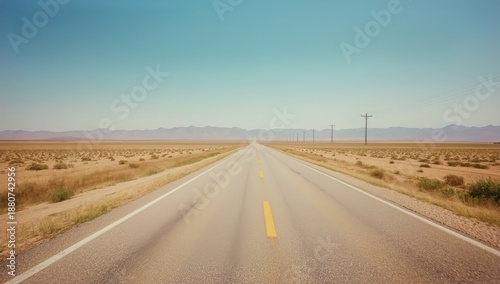 Snowy Road Stretches Into Distance Under Blue Sky With White Clouds