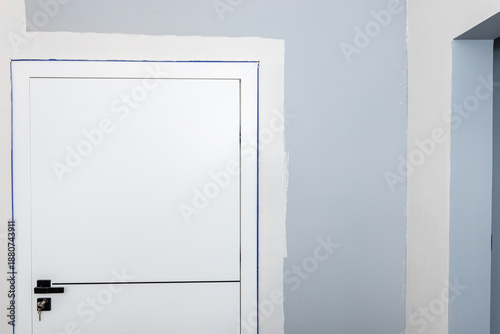 Preparing walls for painting, protecting door frames and ceilings with painters tape.