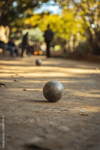 Exciting game of petanque on a dusty path outdoor park sports activity relaxed atmosphere ground level recreational fun