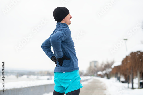 Tableau sur toile Runner experiencing lower back pain during winter exercise