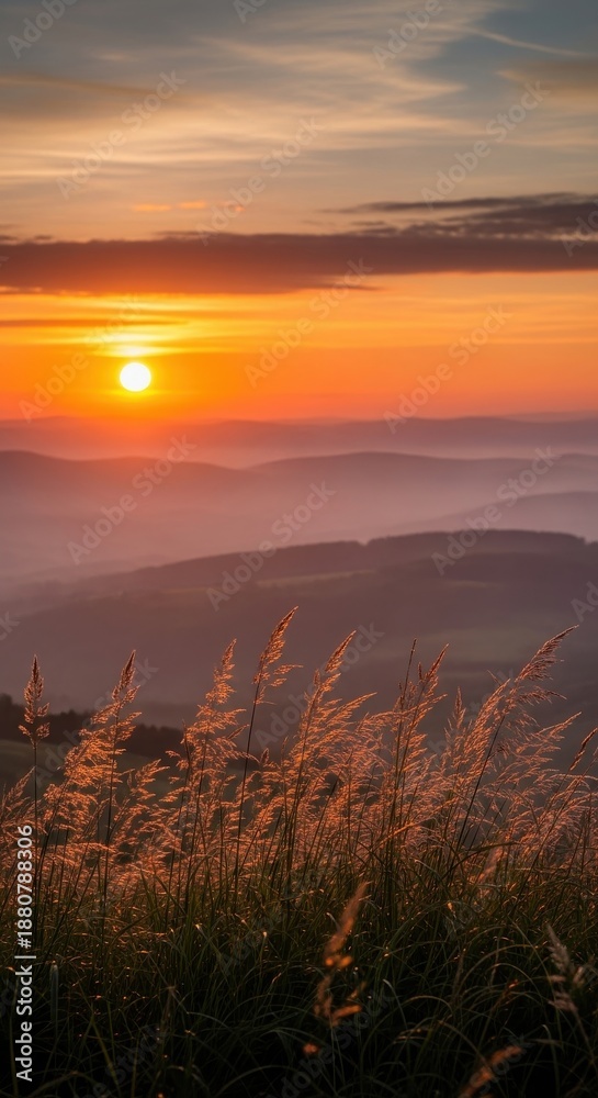 Obraz premium Sunset over mountain layers with grass foreground