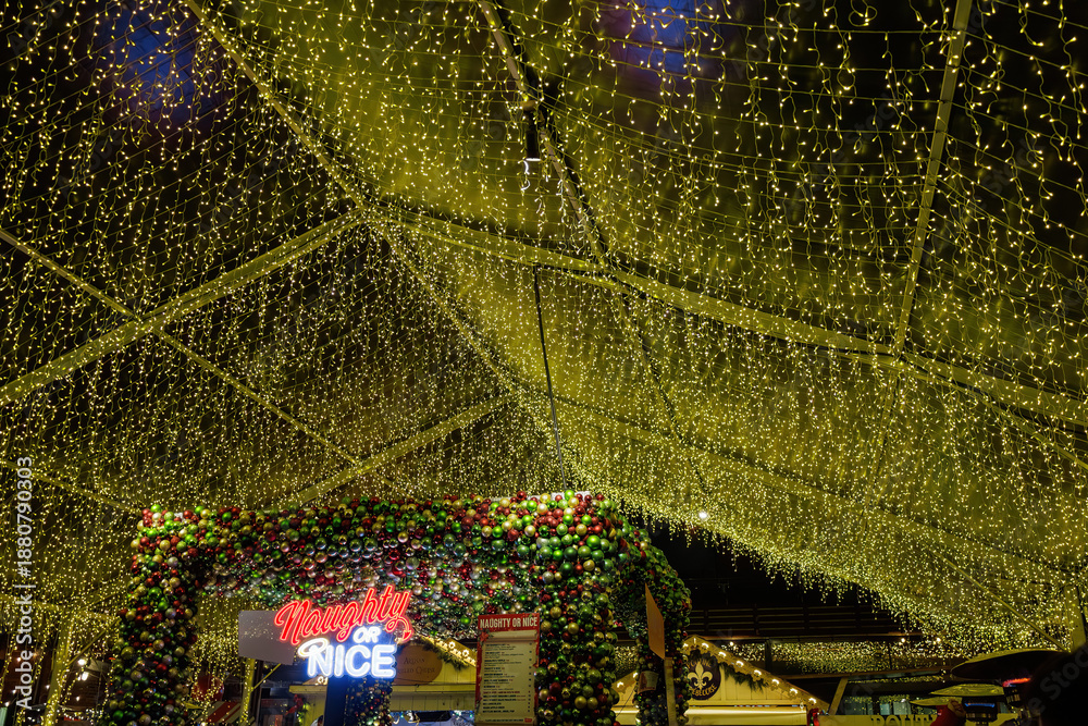 Naklejka premium Canopy of golden Christmas lights illuminating the Naughty or Nice, Distillery District, Toronto, Canada