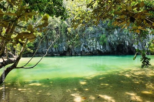 A breathtaking view of the Puerto Princesa Underground River in Palawan, Philippines, showcasing its dramatic limestone cliffs, crystal-clear waters, and lush tropical surroundings.