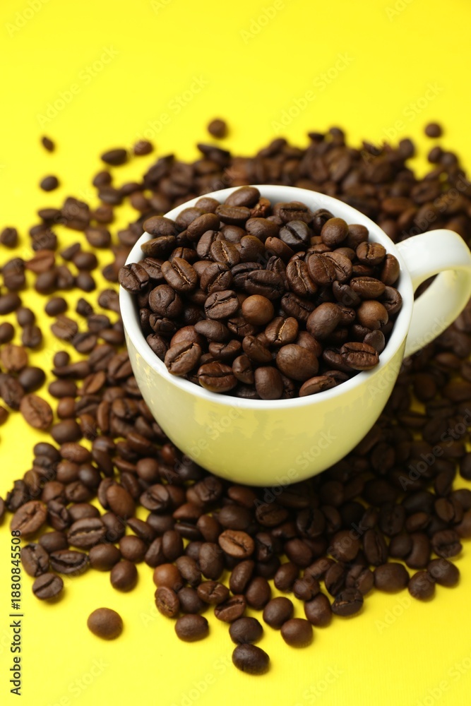 Fototapeta premium Aromatic coffee beans and cup on yellow background
