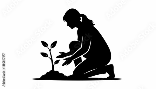 Silhouette of a person kneeling and planting a small sapling in fertile soil.