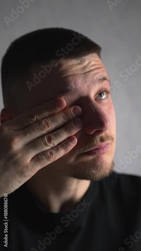 A man suffers from dry eyes.
The man rubs his eyes with his hands, causing discomfort and pain.