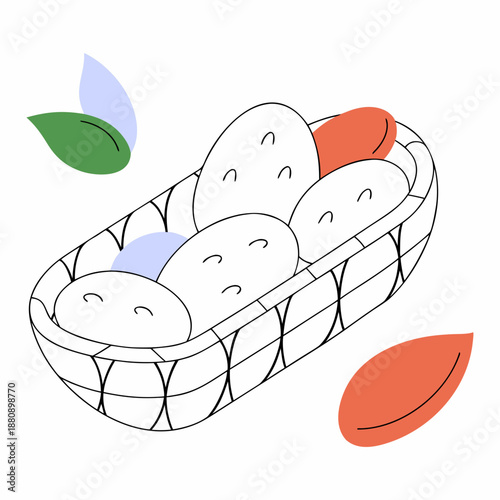 Raw potatoes in shallow woven basket with leaves