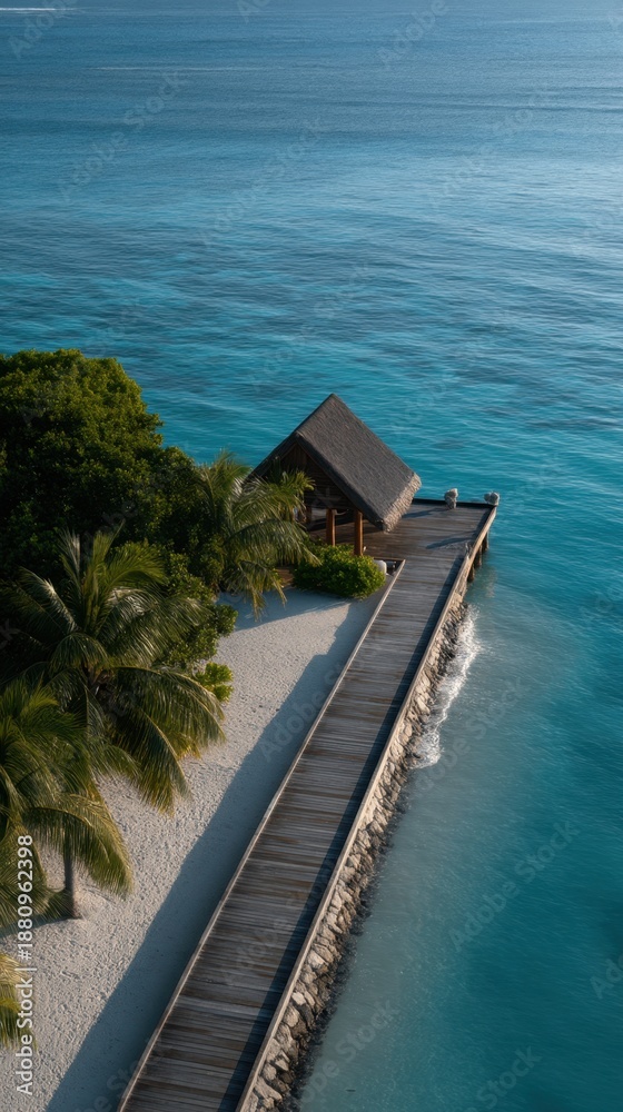 Fototapeta premium Aerial View of a Resort Pier Extending Over the Calm Tropical Ocean Waters