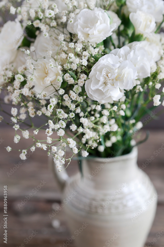 Fototapeta premium White carnations and gypsophila paniculata in one arrangement. Bridal floristry.