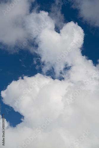 White clouds in a blue sky in poster format. Ideal as a background or for adding text or images.