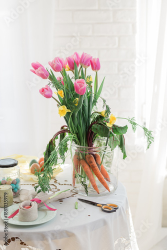 Bouquet of fresh tulips and carrots as unique Easter table decor