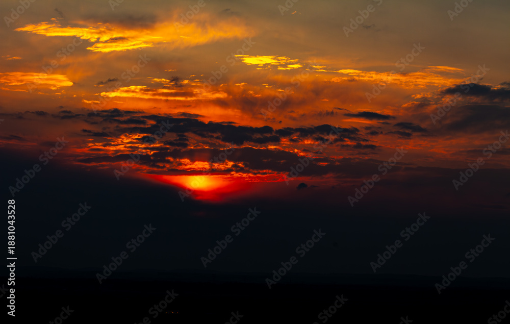 Obraz premium Soleil flamboyant sur l'horizon perçant les nuages dans la campagne du sud de la France