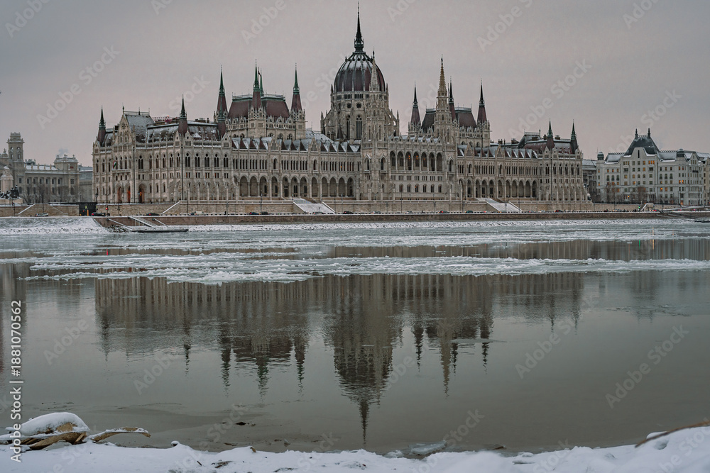 Fototapeta premium Ice floes on the Danube River with Hungarian Parliament in winter