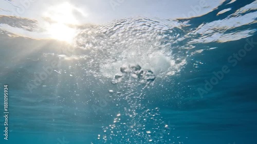 Abstract sunlight piercing deep water, ethereal sunbeams and rising bubbles.