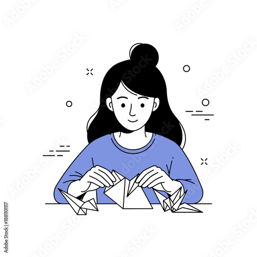 Asian female child engaging in origami crafting activity with paper cranes