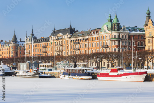 Old beautiful buildings and boats in Stockholm city on a sunny winter day.