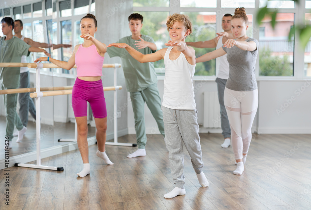 Fototapeta premium Girls and boys are learning various dance and ballet movements in the studio